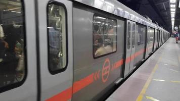 delhi india -junio 21 2022 -tren de metro de delhi que llega a la estación de metro de jhandewalan en delhi, india, asia, metro público que sale de la estación de jhandewalan en el que viajan más de 17 lakhs de pasajeros video