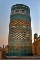 Kalta Minor Minaret and the historic architecture of Itchan Kala, walled inner town of the city of Khiva, Uzbekistan a UNESCO World Heritage Site. photo