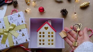 schlüssel zum haus mit schlüsselbund auf gemütlichem zuhause in geschenkbox mit weihnachtsdekorverpackung. pack geschenk für neujahr, weihnachten. Bauen, Projekt, Umzug in ein neues Haus, Hypothek, Miete, Kauf von Immobilien video