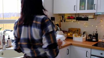 Woman puts it on table and takes food delivery service containers on table white scandi festive kitchen in christmas decor. Eve New year, saving time, too lazy to cook, hot order, plastic box video