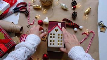 sleutel naar huis met sleutelhanger Aan knus huis in geschenk doos met Kerstmis decor verpakking. pak Cadeau voor nieuw jaar, kerstmis. gebouw, projecteren, in beweging naar nieuw huis, hypotheek, huur, aankoop echt landgoed video