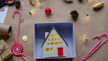 Key to house with keychain on cozy home in gift box with Christmas decor packaging. Pack present for New Year, Christmas. Building, project, moving to new house, mortgage, rent, purchase real estate