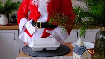 Food delivery to home service containers in hands of Santa Claus puts it on kitchen table and takes it away. Ready-made hot order, Christmas, New year holidays catering. video