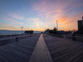 Dramatic Sunset along the boardwalk of Coney Island in Brooklyn, New York photo