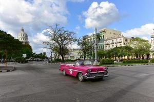 Havana, Cuba - January 7, 2016 -  Classic cars driving along the wide boulevard Paseo del Prad in Havana, Cuba. photo