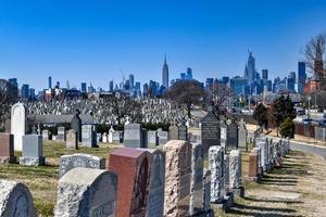 New York City - Feb 23, 2020 -   Calvary Cemetery with Manhattan skyline in New York. Calvary Cemetery is a cemetery in Queens, containing more than 3 million burials. photo