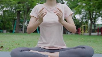 woman practicing meditate on the park. Asian woman doing exercises in morning. balance, recreation, relaxation, calm, good health, happy, relax, healthy lifestyle, reduce stress, peaceful, Attitude. video