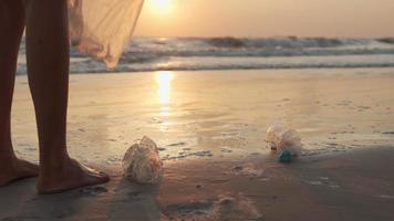 économiser l'eau. les volontaires ramassent les ordures à la plage et les bouteilles en plastique sont difficiles à décomposer pour éviter de nuire à la vie aquatique. terre, environnement, verdir la planète, réduire le réchauffement climatique, sauver le monde video