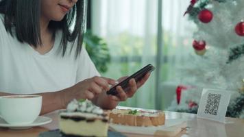 Woman use smartphone to scan QR code to pay in cafe restaurant with a digital payment without cash. Choose menu and order accumulate discount. E wallet, technology, pay online, credit card, bank app video