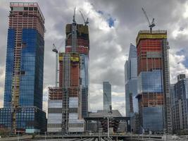 View of the Hudson Yards train depot and building development seen from the High Line, an elevated green urban park running along old rail track lines in New York City. photo