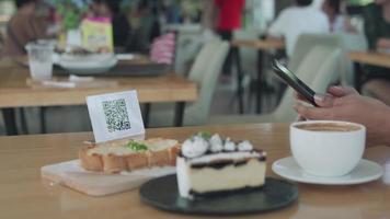 vrouw gebruik smartphone naar scannen qr code naar betalen in cafe restaurant met een digitaal betaling zonder contant geld. Kiezen menu en bestellen accumuleren korting. e portemonnee, technologie, betalen online, credit kaart, bank app video