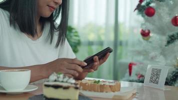 kvinna använda sig av smartphone till skanna qr koda till betala i Kafé restaurang med en digital betalning utan kontanter. välja meny och beställa ackumulera rabatt. e plånbok, teknologi, betala uppkopplad, kreditera kort, Bank app video