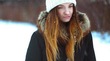 Cheerful girl in winter outside in a snowstorm posing video