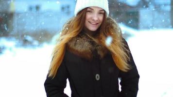 Charming girl in winter outside in a snowstorm posing video