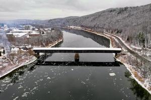 el puente cubierto de cornualles-windsor. conecta vermont y new hampshire en sus fronteras. es el puente cubierto más largo del mundo con 460 pies. fue construido en 1866. foto