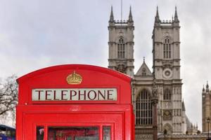 Red Telephone Box in London against the backdrop of Westminster Abbey. photo