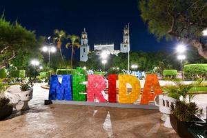 Big colorful letters representing Merida with an iconic Merida Cathedral at the background at night. photo