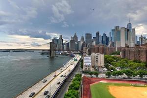 New York City - Jun 28, 2020 -  Panoramic view of the East River and the Brooklyn Bridge between Brooklyn and Manhattan in New York City. photo
