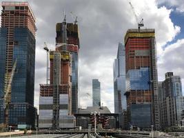 View of the Hudson Yards train depot and building development seen from the High Line, an elevated green urban park running along old rail track lines in New York City. photo