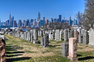 New York City - Feb 23, 2020 -   Calvary Cemetery with Manhattan skyline in New York. Calvary Cemetery is a cemetery in Queens, containing more than 3 million burials. photo