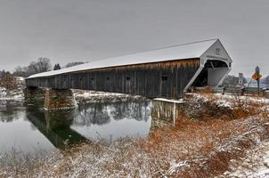 el puente cubierto de cornualles-windsor. conecta vermont y new hampshire en sus fronteras. es el puente cubierto más largo del mundo con 460 pies. fue construido en 1866. foto