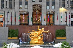 New York, NY, USA - Jul 2, 2020 -  Real estate firm Tishman Speyer fitted masks on Prometheus and other classic statues in Rockefeller Center to remind New Yorkers to wear COVID-19 face coverings. photo