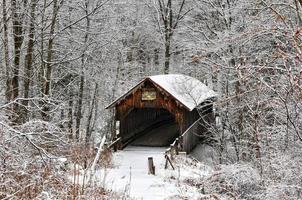 herrería puente cubierto durante el invierno en new hampshire. Construido en 1882, es un histórico puente cubierto que cruza Mill Brook cerca de Town House Road en Cornualles, New Hampshire, Estados Unidos. foto