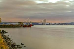 New and Old Tappan Zee Bridges coexisting across Hudson River with a dramatic sunset. photo