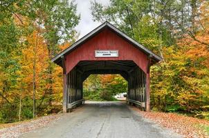 Brookdale Covered Bridge in Stowe, Vermont during fall foliage over the West Branch Little River. photo