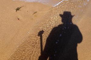 la sombra del fotógrafo en la orilla del mar. foto