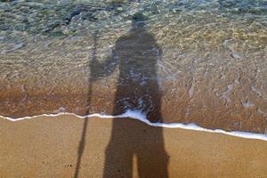 la sombra del fotógrafo en la orilla del mar. foto