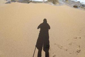 la sombra del fotógrafo en la orilla del mar. foto