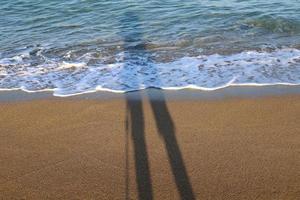 la sombra del fotógrafo en la orilla del mar. foto