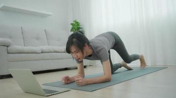 schlanke asiatische frau, die yoga auf eigentumswohnung praktiziert. schöne Frau, die morgens Übungen macht. balance, erholung, entspannung, ruhe, gute gesundheit, glücklich, entspannen, gesunder lebensstil, stress abbauen, friedlich. video