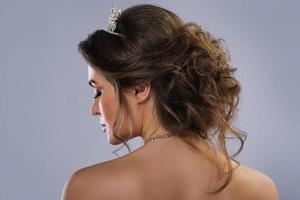 Beautiful bride with a stylish hairdo isolated on gray background photo