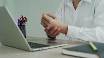 attività commerciale uomo spremitura il suo polso per alleviare dolore nel il suo braccio. donna d'affari ha un' dolore nel sua polso a partire dal utilizzando il computer per un' lungo volta. concetto ufficio sindrome video