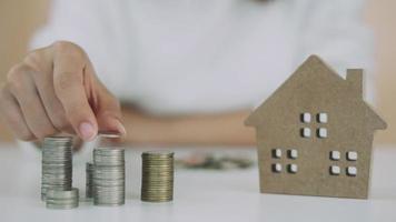 donne mantenere i soldi per investire per il futuro. persone mettere monete per acquistare casa. Salva i soldi per investimento e Casa concetto e Riserva. video