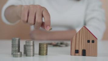 donne mantenere i soldi per investire per il futuro. persone mettere monete per acquistare casa. Salva i soldi per investimento e Casa concetto e Riserva. video