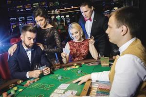 Group of rich people is playing poker in the casino photo