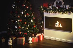 Christmas gifts and decorations beside the cosy fireplace photo