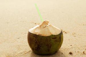 bebida de coco fresca en la playa de arena foto