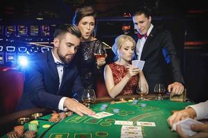 Group of rich people is playing poker in the casino photo