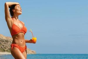 Woman on the beach with a glass of cocktail photo