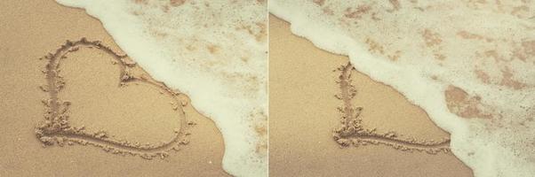 Drawing of a heart shape on the sand and wave with foam photo