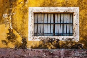 Old window and wall of colorful grungy house photo