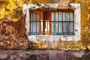 Old window and wall of colorful grungy house photo