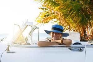 bella mujer con sombrero azul y cabriolé retro blanco foto