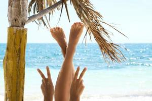 Woman is showing peace or victory gesture on the beach photo