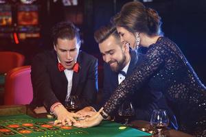 gente hermosa y rica jugando a la ruleta en el casino foto