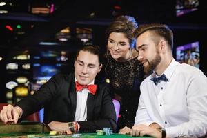 Beautiful and rich people playing roulette in the casino photo